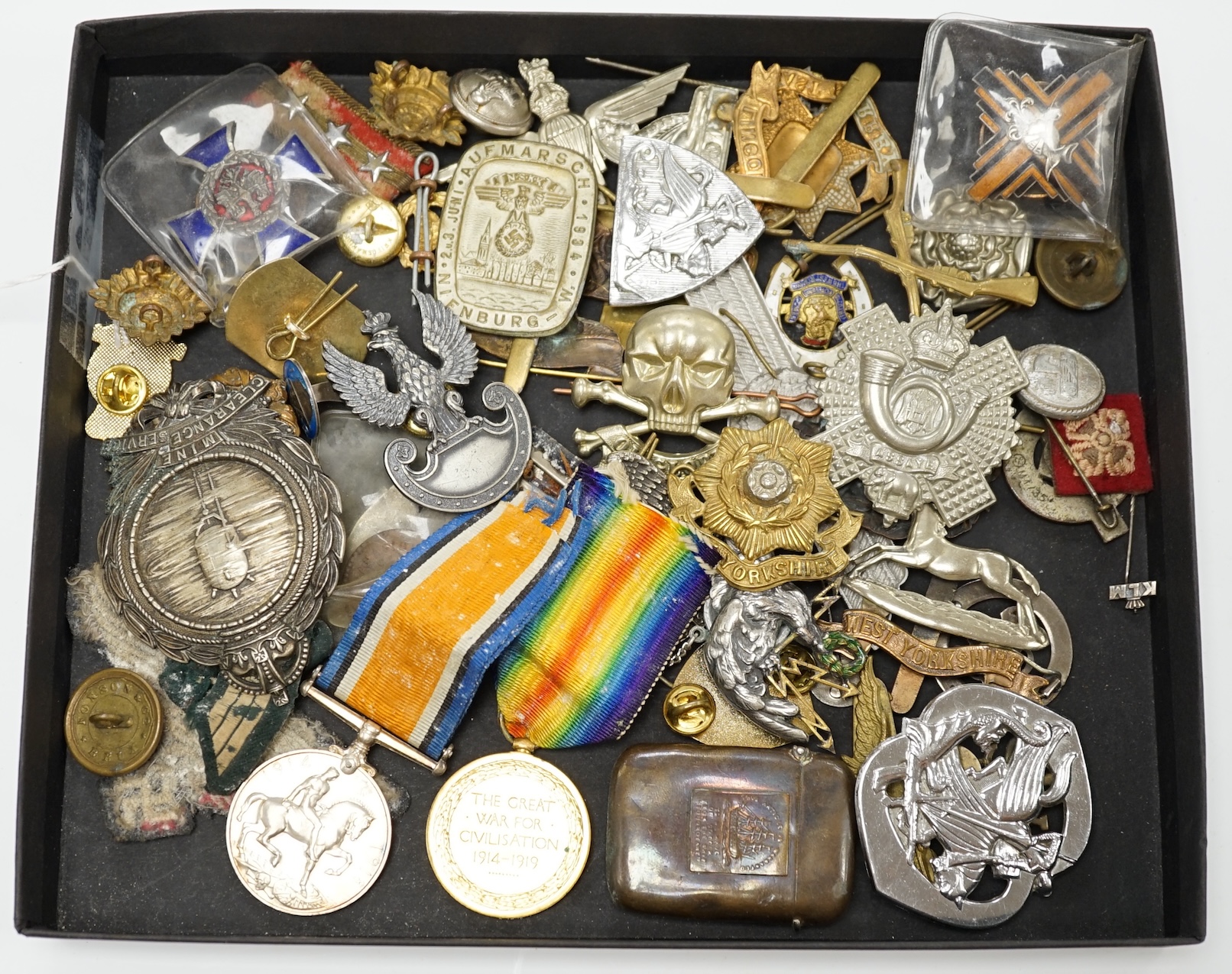 A collection of military cap badges and medals, including a First World War medal pair awarded to A.M. F.W. Wright, together with seventeen British and German cap badges including; the West Yorkshire Regiment, the Royal